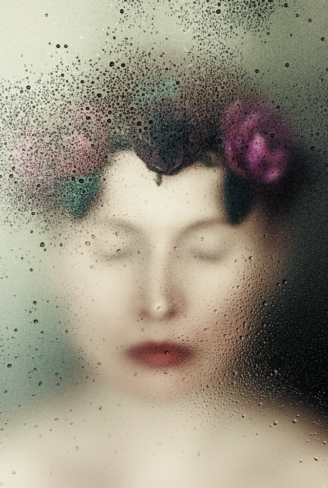 Manuela Deigert Bildsprache verträumtes Selbstportrait mit Blumenkranz hinter einer nassen Scheibe