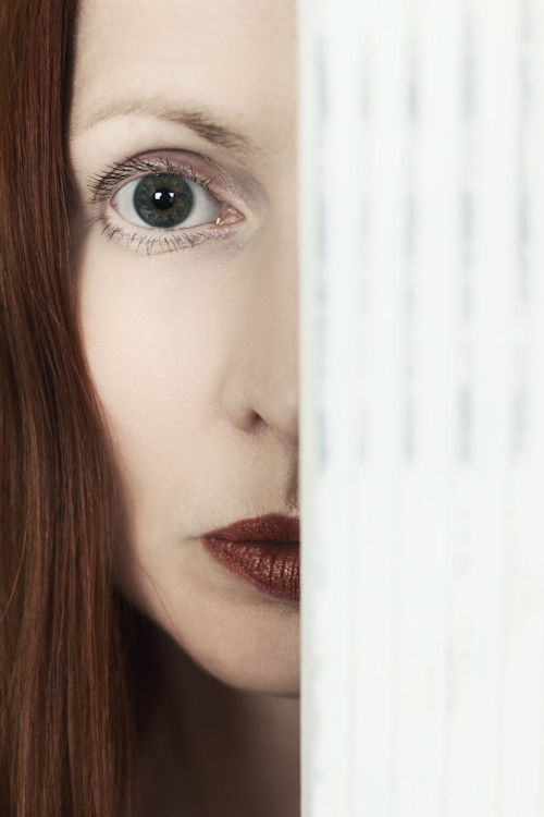 Manuela Deigert Bildsprache, halbes Selbstportrait hinter einem weissen Holzstück
