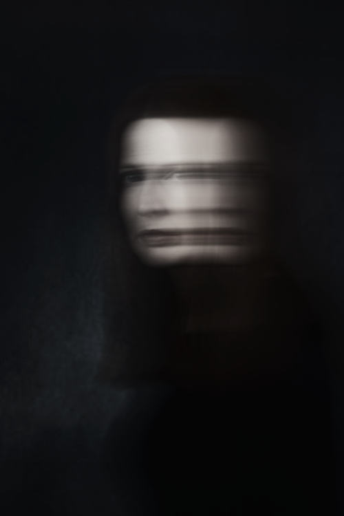 Manuela Deigert Projekte Inner conflict Frauenportrait Gesicht und Oberkörper dreht sich dynamisch unscharf