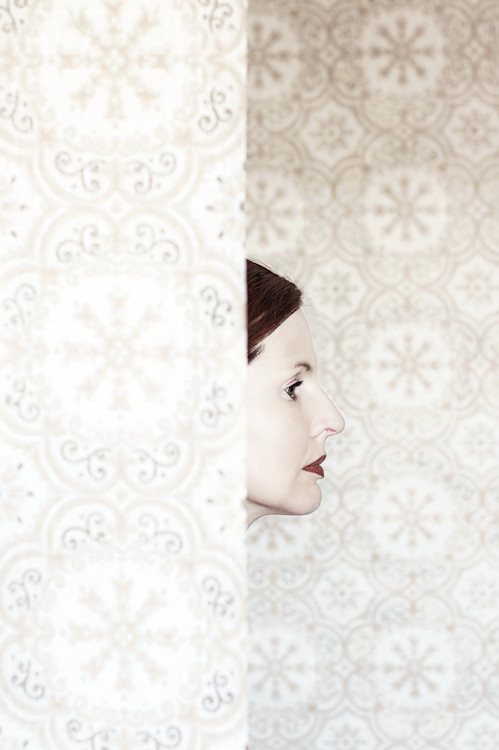 Manuela Deigert Projekte A touch of vintage, Selbstportrait im Profil teils verdeckt durch eine Tapete im Vintage Stil
