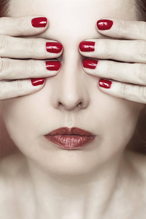 Manuela Deigert Bildsprache, Selbstportrait mit rotlackierten Fingernägeln, die Hände vor die Augen haltend 