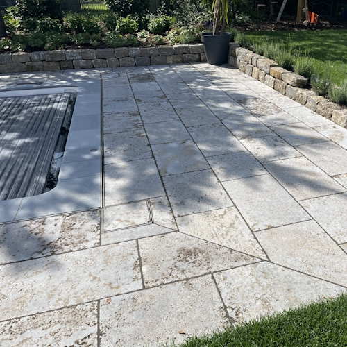 Schlitzrinne und Muschelkalkplatten um den Pool
