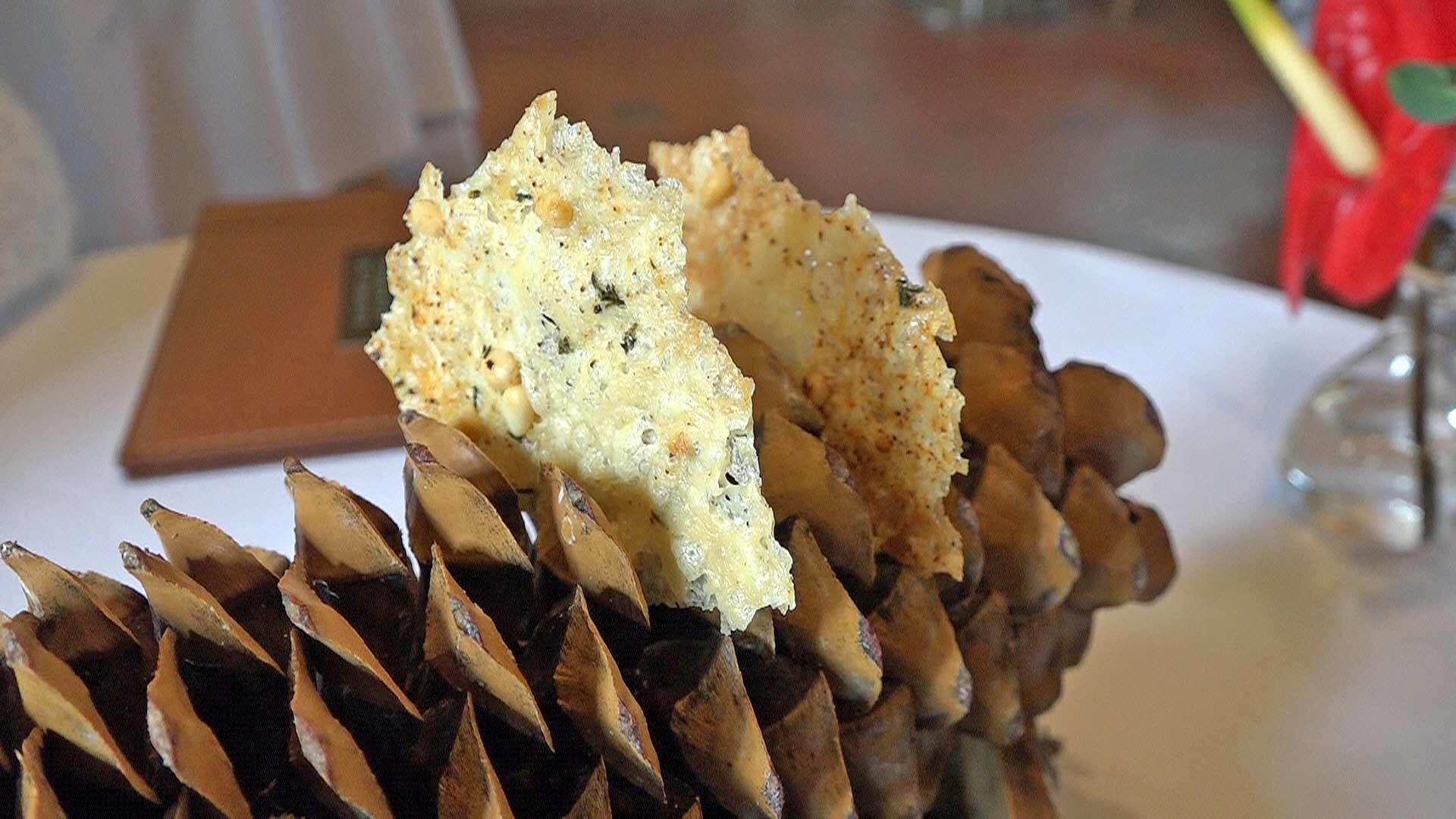 Amuse-bouche : Tuile de Comté/Parmesan présentée sur une pomme de pin