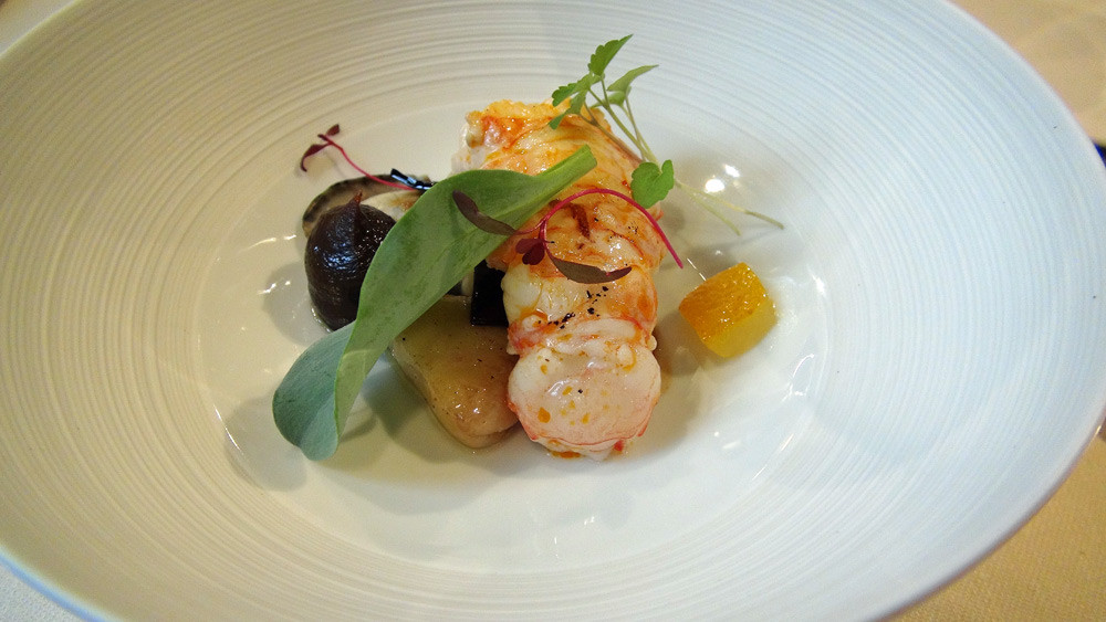 Langoustine d'Ecosse saisie à la plancha, huître pochée au four dans sa coquille, kumbu en beurre et en carrés confits, moelle de bœuf et mertensia 