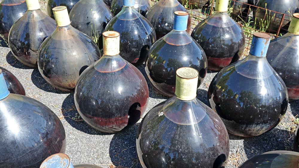 Quelques dames-jeannes vues de plus près avec leur boite de conserve protectrice