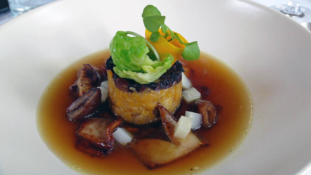 Sur une galette de pain et de potimarron au boudin noir, quelques cèpes, un jus d'oignons caramélisés