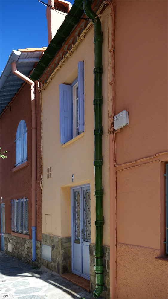 Dans une rue étroite de Collioure, une gouttière en céramique