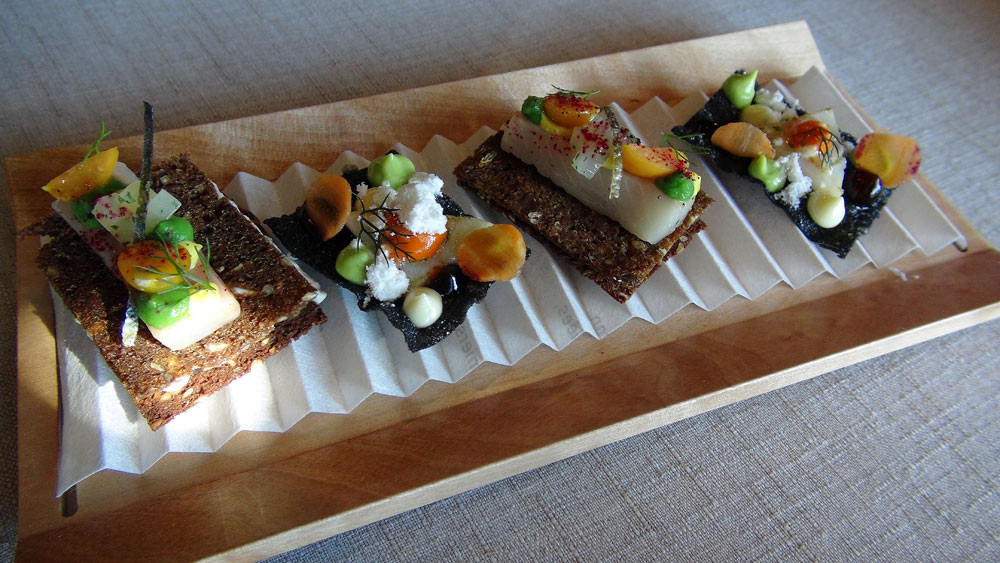 Cracker au Cantal à l'encre de seiche et calamar juste saisi - Pain noir et mélasse, fromage blanc aux herbes, truite fario en gravelax