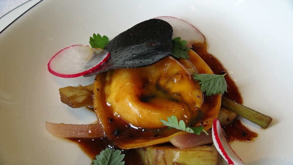 Ravioli garni de jaune d’œuf de ferme confit/cœur coulant truffé, primeurs fondants aux truffes, coupé