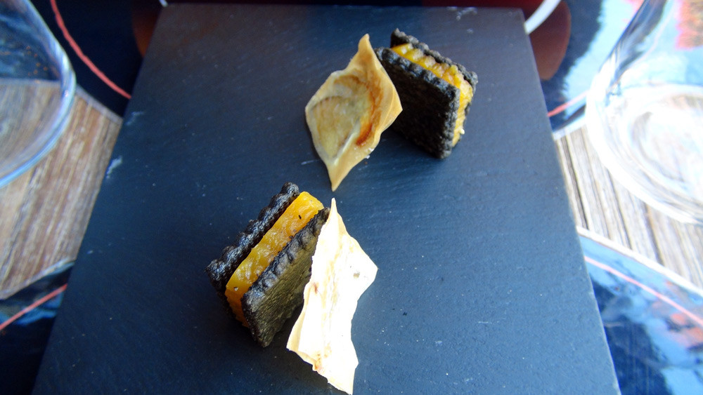 Amuse-bouche : Sablé de parmesan à l'encre de seiche, garni de buterrnut confit - Chips et sa lame de cèpe cristallisé
