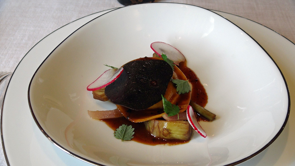 Ravioli garni de jaune d’œuf de ferme confit/cœur coulant truffé, primeurs fondants aux truffes