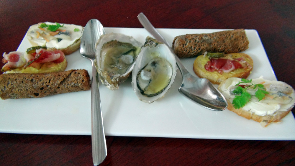 Les amuse-bouche : Huitre de Jersey et huile de basilic,  Galette sarrasin/saucisse, Toast de filet d'anchois mariné et Toast de saucisson du marin, moutarde Savora 