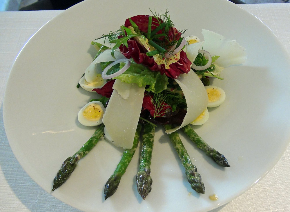 L'asperge servie en mesclun nourri d'herbes aromatiques, du parmesan et des oeufs de caille
