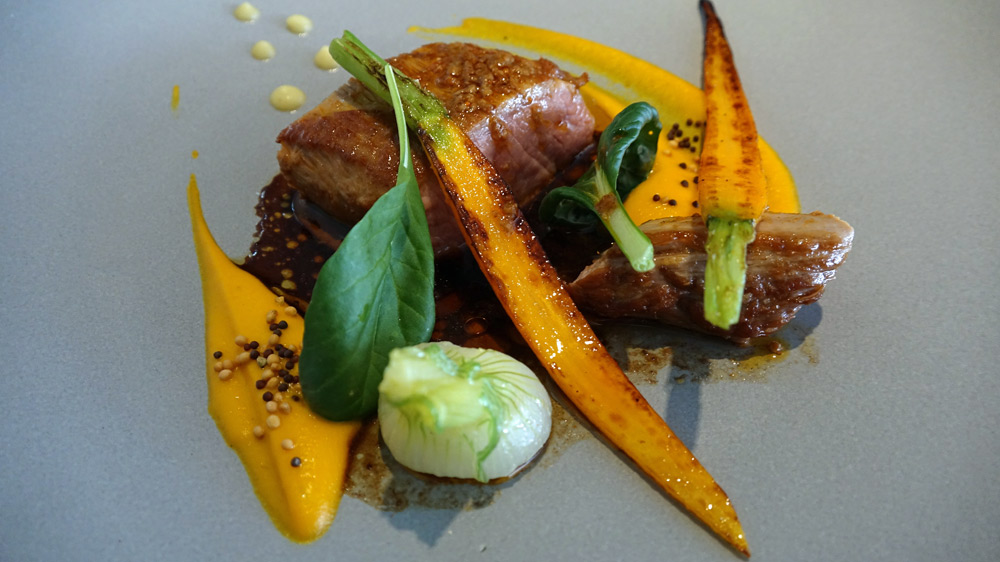 Selle d'agneau, carottes snackées, oignon blanc, jus moutarde à l'ancienne, pomme fruit et curry