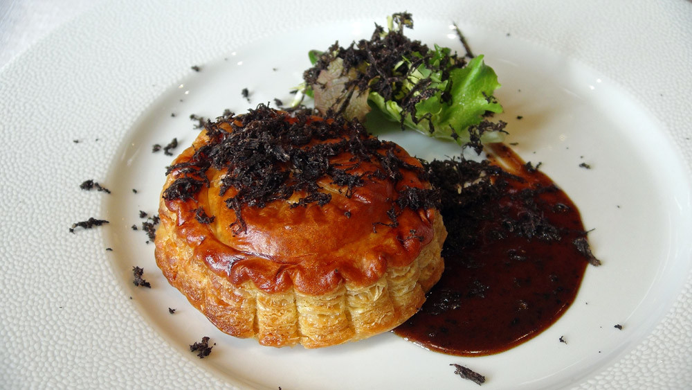 Pithiviers de foie gras et truffe, avec sa sauce Périgueux, quelques pousses d’hiver en vinaigrette, râpée de truffes