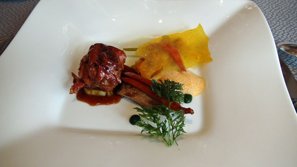 Epaule d’agneau cuite doucement dans ses sucs aux épices, tartine de jeunes carottes et lard de Cul noir au carvi, tuile aromatique