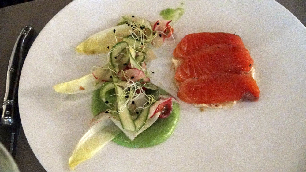 Saumon gravelax, chair de tourteau assaisonné, légumes de saison croquants et coulis de petits pois 