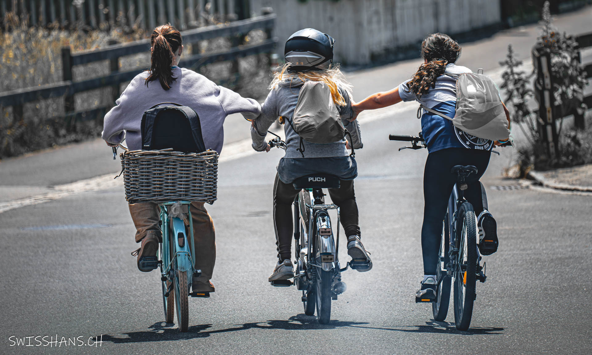 drei junge frauen-velo-mofa-strasse-einhängen