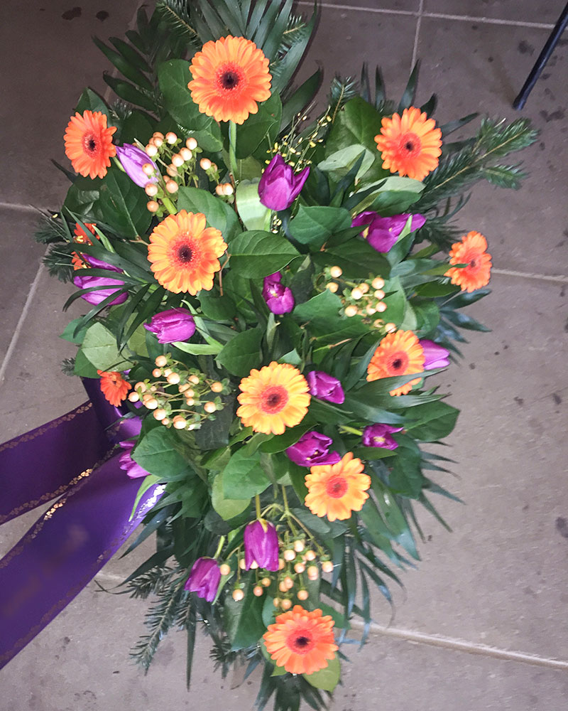 Frischblumenbukett in Tropfform mit orangen Germini, lila Tulpen und creme Hypericum