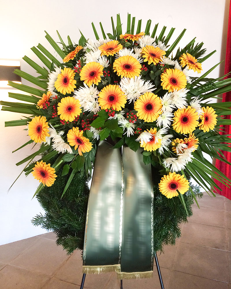 Trauerkranz mit gelben Gerbera und weißen Chrysanthemen gefüllt.