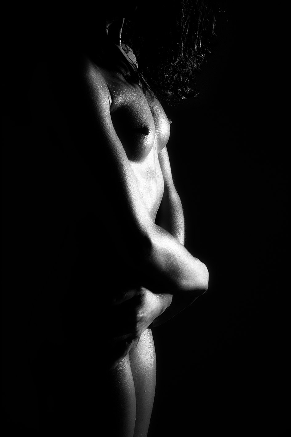 BW image showing the muscular body with very dark dramatic light