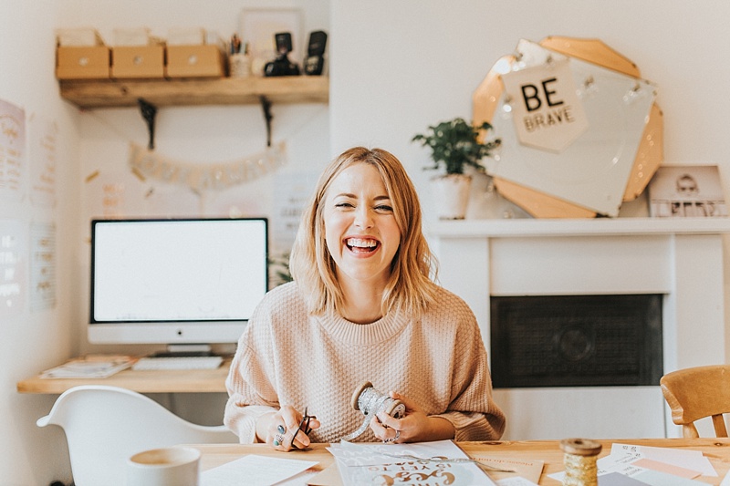 Wedding stationer in her studio laughing at the camera