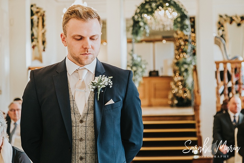 groom waiting patiently at the alter