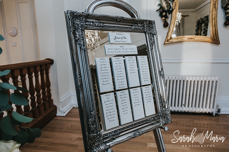 a wedding seating plan on a vintage pewter mirror