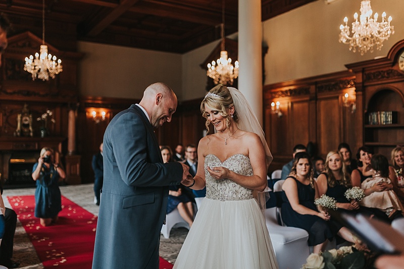 bride and groom exchanging rings in the oak room in York