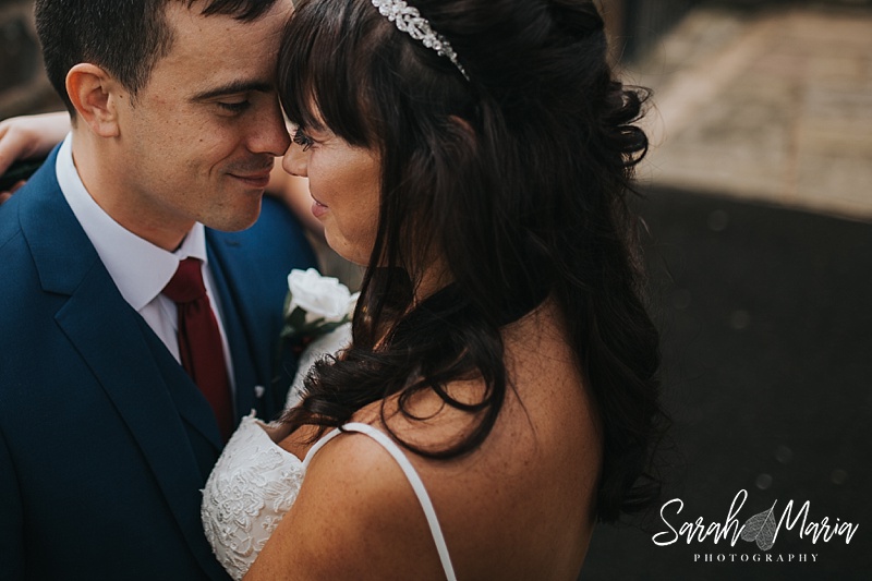 an intimate portrait of a bride and groom holding their heads together