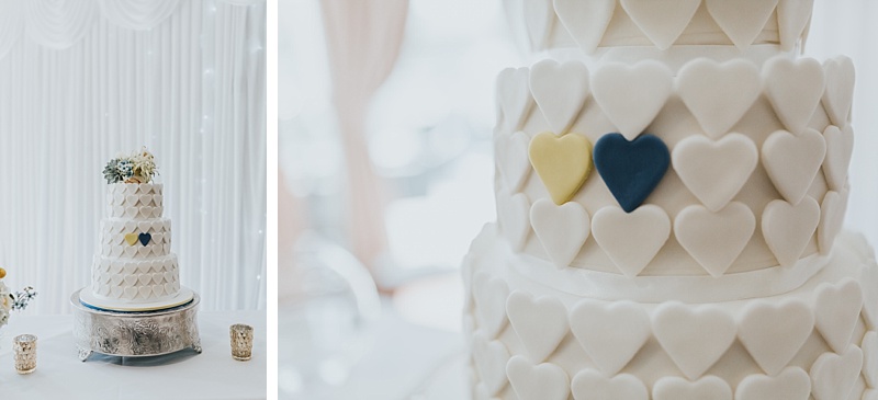 wedding cake with fondant hearts. Two of the hearts are coloured yellow and blue