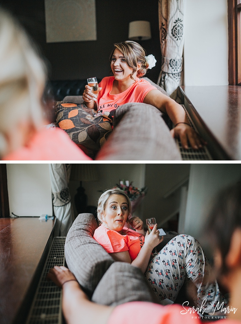 a candid photograph of a bridesmaid sat on the couch with a glass of prosecco