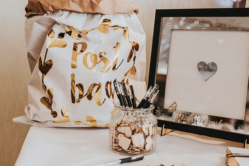 Guest book idea for a wedding with a paper post bag and gold foil writing