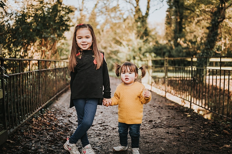 portrait of two sisters on a bridge at the park