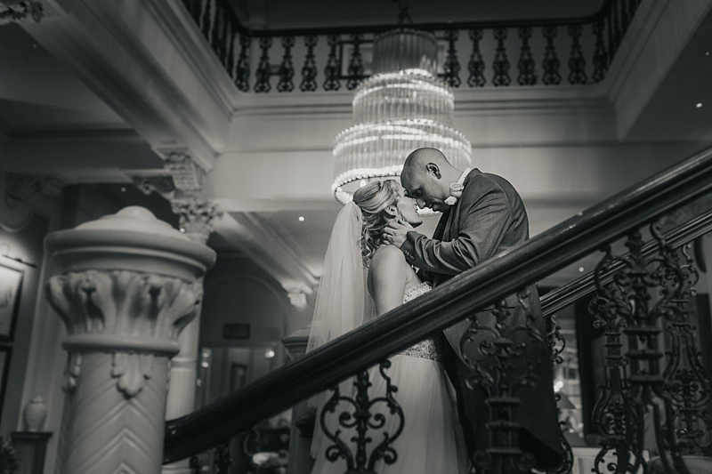 black and white picture of a bride and groom on a grand staircase