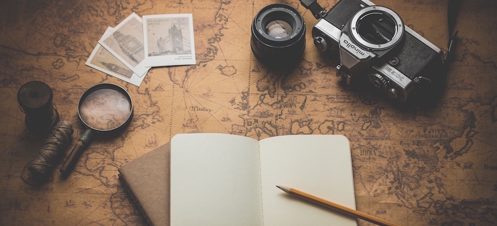 World map, old camera, pen, papers, pictures, a diary, some yarn and a magnifying glass: All you need for a travel adventure?