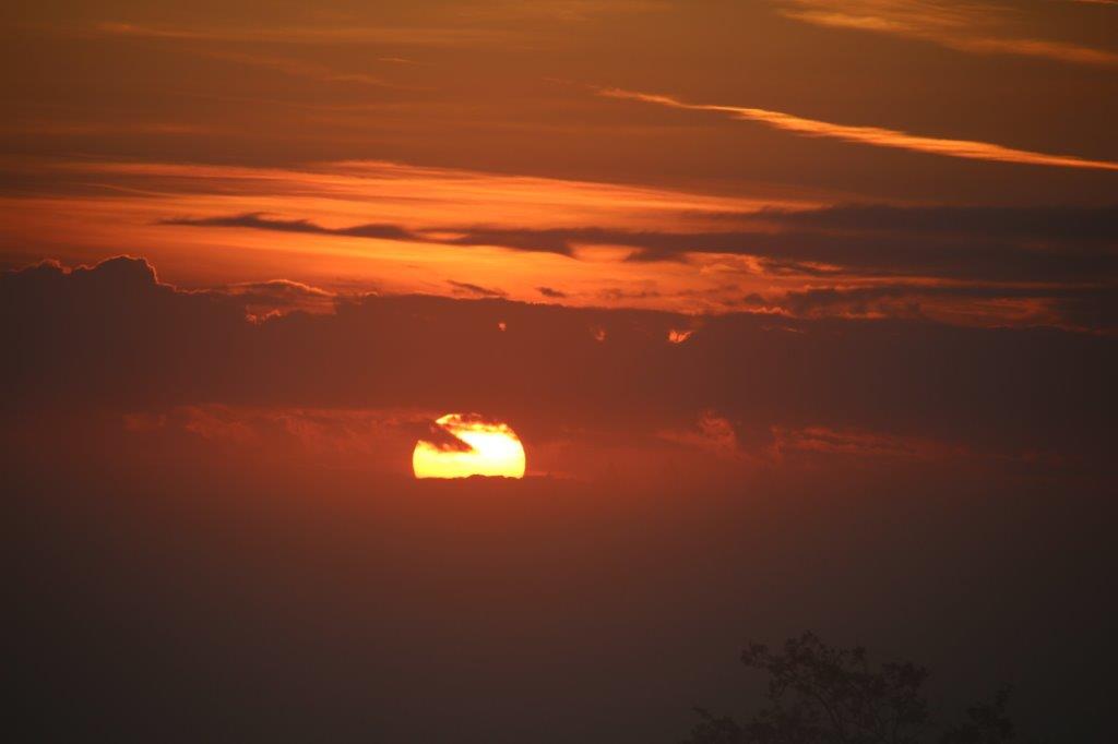 Sonnenaufgang zwischen Wolkenbahnen