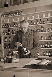 Der Krieg hält Einzug. Ein Mann hält eine Apothekerflasche in der Hand