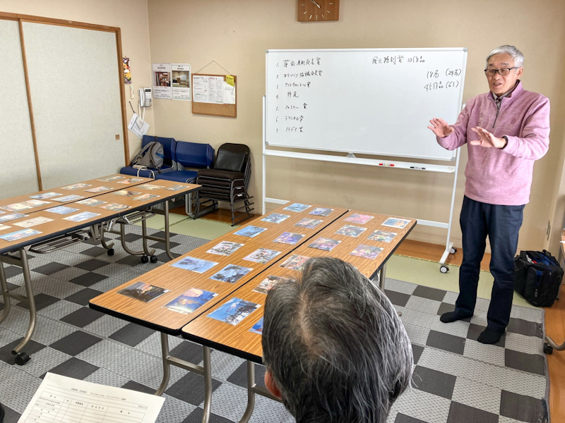 2026フォトコンテスト審査会 出品状況と審査方法について説明する鈴木光典連町総務部長