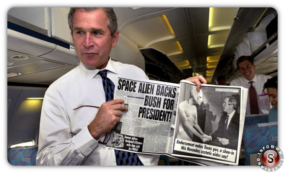 George w. Bush con il giornale che lo raffigura mentre stringe la mano ad un alieno