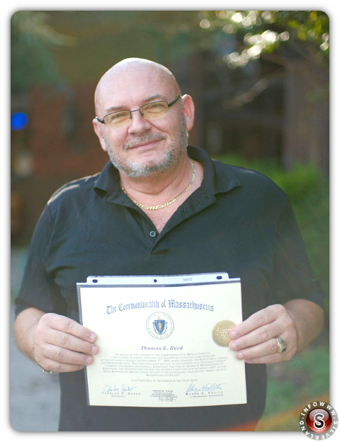 Thom Reed posa per una foto in possesso di un certificato del governatore del Massachusetts che certifica l'avvistamento UFO di Reed