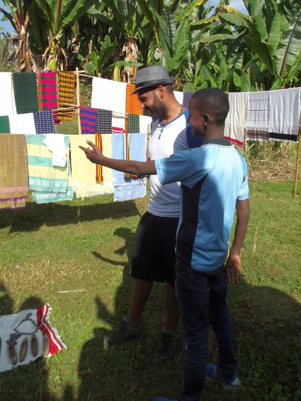 Les écharpes de Dorzé montré par Migbaru, mon fils adoptif et guide éthiopien au travail. Voyage Séjour Trek Trekking Randonnée Road Trip en Ethiopie Visite de la Vallée de l'Omo en Ethiopie. La Ville de Dorze, Le Marché