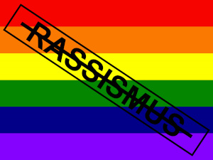 Das Gegen Rassismus 20.1-dÜsign von Thorsten Hülsberg wird hier schräg auf einer Regenbogenfahne präsentiert.