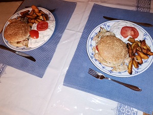 Diese Farbfotografie von Thorsten Hülsberg zeigt zwei garnierte Teller mit Chicken Burgern.