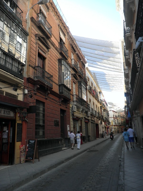 Toiles tendues au-dessus des rues pour les protéger du soleil.