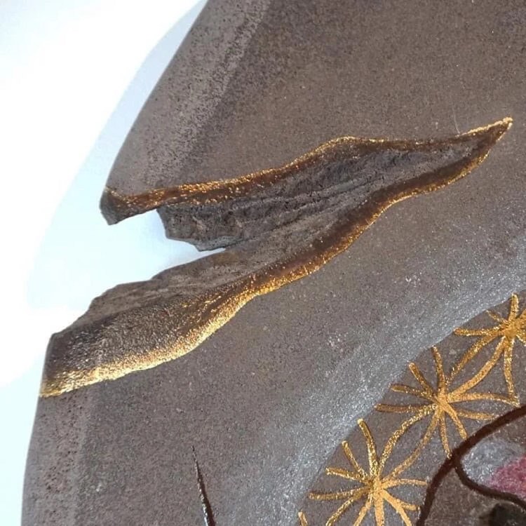 Détail, grande création murale « œuf de vie » en lave émaillée des volcans d’Auvergne et touches d’or.