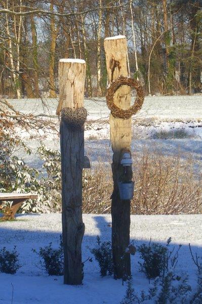Holzskulpturen mit Alpakamotiv im Schnee