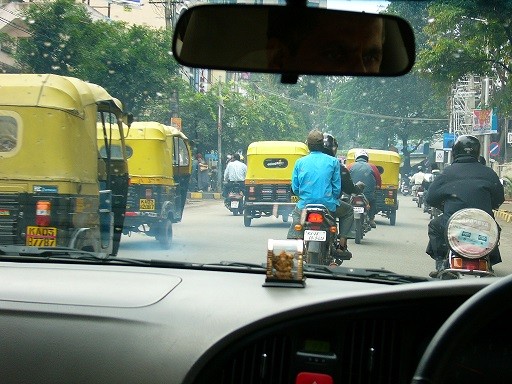 Zweiräder und die gelben "Taxis" prägen das Bild in Indien