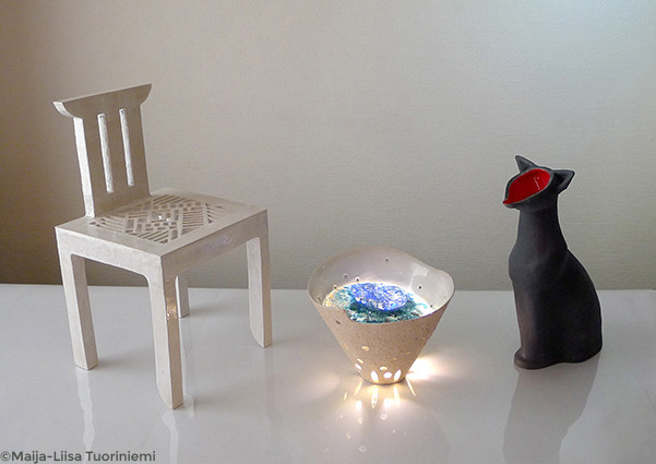 Installation "At the source" en trois pièces. Chaise mandala en céramique émaillée blanc ; récipient cônique en céramique émaillée sable, avec une plaque de verre fusionné coloré et un système d'éclairage LED ; récipient en forme de chat, émaillé noir mat