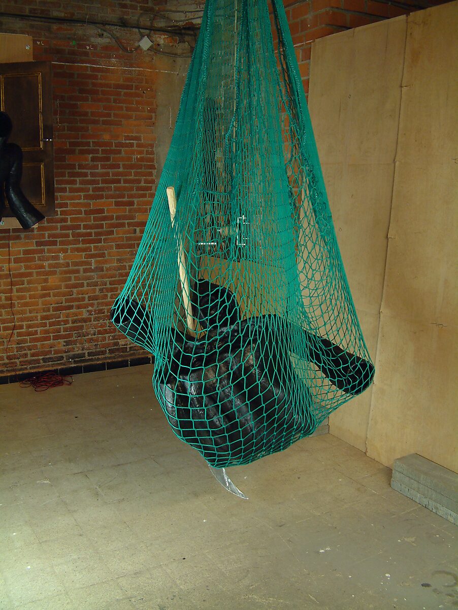 Doodsval nr. 2 — detailaanzicht van de zwarte figuur samengedrukt in een groen net, waarbij de vorm van een lichaam en sikkel gedeeltelijk zichtbaar blijft.